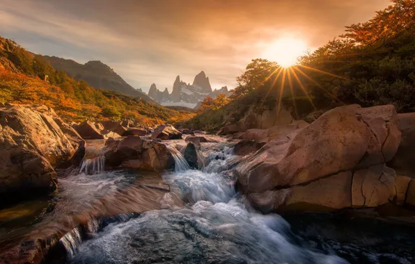Picture the sun, rays, mountains, river, stones, dawn, waterfall