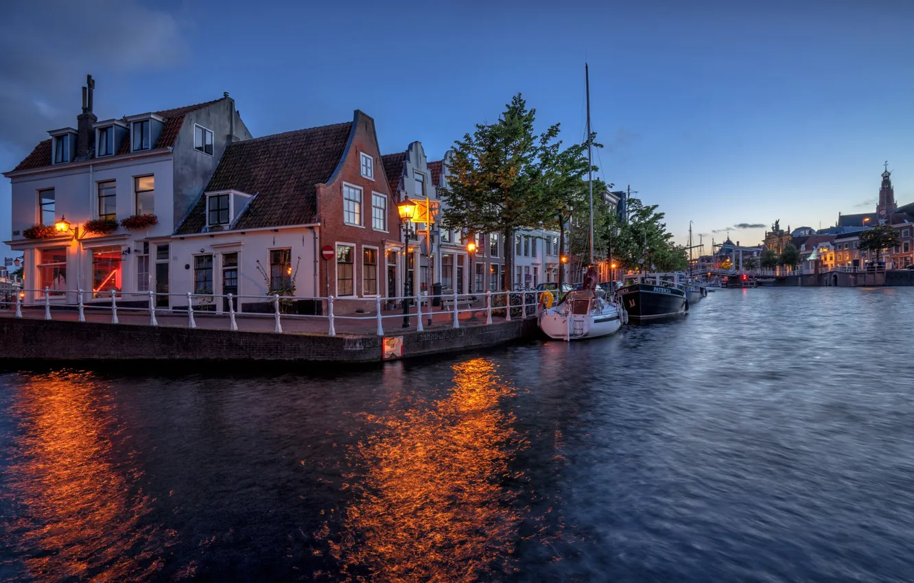 Photo wallpaper the city, river, home, boats, the evening, lighting, Netherlands, twilight, Haarlem, The guy near